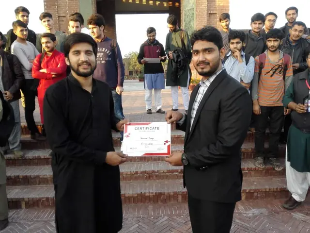 Usman Saeed presenting a certificate to a student outside the COMSATS Lahore campus gate